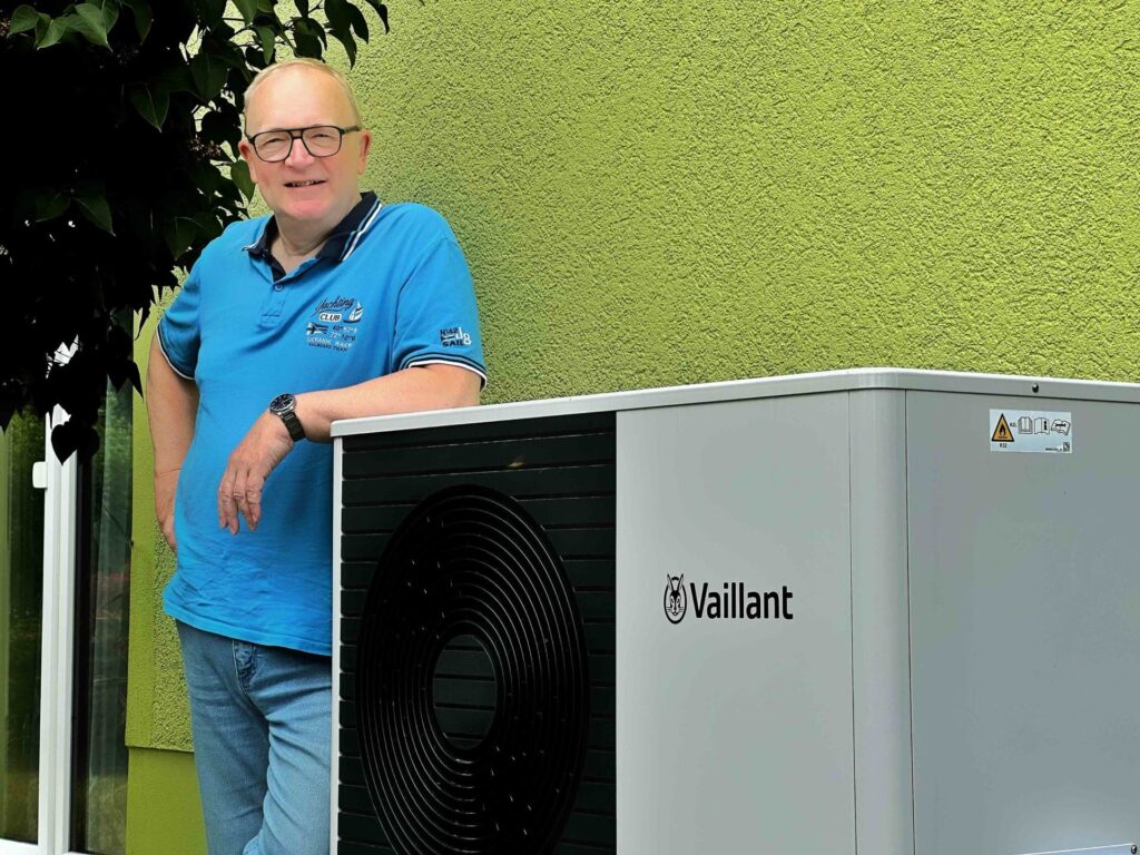 Holger Schleife aus Bannewitz vor der Außeneinheit seiner neuen Luft-Wasser Wärmepumpe Vaillant aroTHERM-split, die in einer vorhandene Dachzentrale eingebunden worden ist.